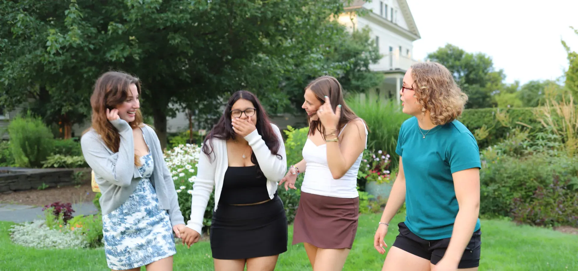 Four Precollege students laughing together.